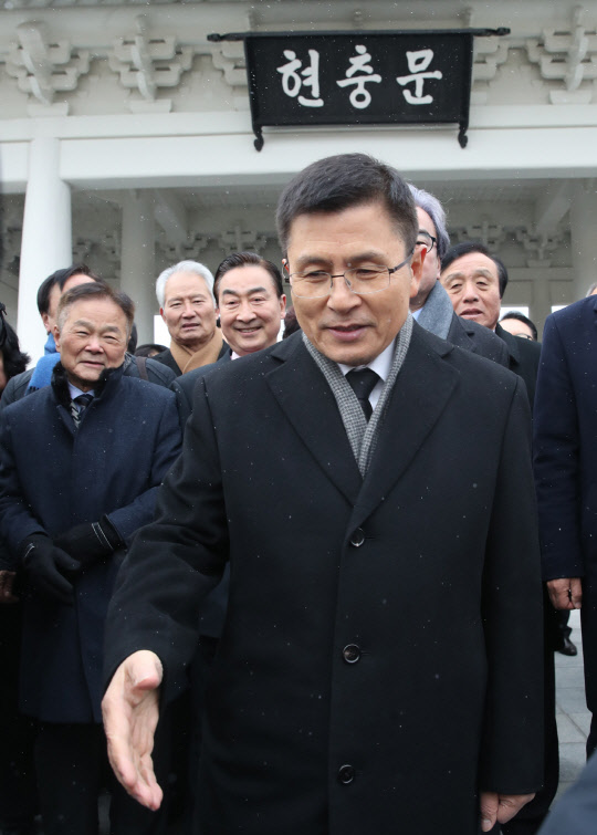 황교안 자유한국당 대표가  2020년 새해 첫날인 1일 서울 동작구 국립서울현충원 참배를 마친 뒤 한 지지자에게 악수를 청하고 있다. 연합뉴스